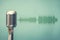 antique microphone on green background and audio waveform