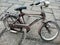 an antique miniature bicycle classic parked on paving block floor