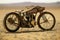 An Antique Motorcycle, Weathered by Time, Rests in The Midst of an Expansive Desert Landscape