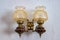 Antique pair of wall lamps over a white wall