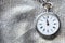 antique pocket watch on silver textile background