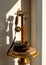 Antique polished wood candlestick telephone on marble table