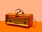 An antique radio with old type of headphones. Retro vibe arrangement against light orange and light orange background
