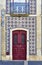 Antique red wooden door of a tiled house.