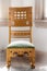 Antique rocking chair with fancy woodwork and carvingg int he corner of a room - Close-up.j