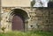 Antique Romanesque door on a rustic stone wall