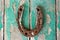 Antique rusty horseshoe on weathered green wooden surface