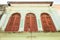 Antique shuttered windows in antique house in Phuket  viewed from below. Old town in Thailand. Vintage  home  tourist attraction.