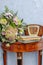 Antique sideboard with flowers, old clock and old books