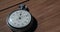 An Antique Stopwatch Lies on Wooden Table and Counts the Seconds