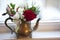 Antique tarnished teapot with red rose, berries and white flowers