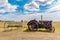 Antique tractor pulling a hay rake with St. Anthony Roman Catholic Church in Illerbrun, SK in the backg