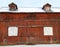 Antique vintage red gable barn with sliding doors and dormer roof windows