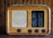 Antique vintage wooden radio on wood wall background. The black glass with the city names is written in italian .