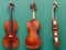 Antique violin from all sides on green background