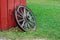 Antique Wagon Wheel Leaning against a Red Barn