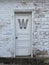 Antique white door with a W on it.