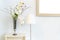 Antique white wooden cabinet and standing lamp light bulb, beautiful flower in vase glass with golden vintage blank photo frame