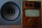 Antique wooden ammeter against the background of an antique broadband speaker.