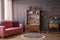 Antique wooden bookcase with decorations in an elegant gray living room interior with a comfortable powder pink sofa