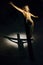 Antique wooden crucifix illuminated inside a historic Italian church with shadow cast on the wall