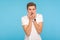 Anxiety and panic. Portrait of scared worried man in white t-shirt biting nails, suffering phobia