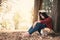 Anxiety woman about her studying sitting lonely under the big tree on park