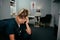 Anxious caucasian female nurse sitting in clinic with headache