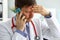 Anxious doctor listens to complaints by phone.