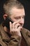 An anxious middle-aged man calls and talks on the phone. Close-up. Studio portrait