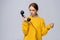 Anxious woman in stylish yellow sweater holding handset receiver of retro phone and looking away