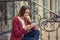 Anxious Woman watching media in a mobile phone sitting outdoors outside near her home in Manhattan New York background