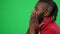 Anxious worried football fan supporting team reacting emotionally on green screen. Side view close-up of African