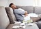 Anyone want to trade places. Portrait of a sickly young man holding a pillow while sitting on a couch with tissues