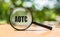 AOTC American Opportunity Tax Credit - magnifying glass with text on wooden table and green background. Business concept image