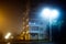 Apartment block on empty night city street covered with fog