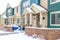 Apartment home facade with gabled entrances and porches on a snowy winter day