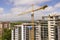 Apartment or office tall building under construction. Brick walls, glass windows, scaffolding and concrete support pillars. Tower