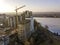 Apartment or office tall building under construction, top view. Tower crane and city landscape stretching to horizon. Drone aerial