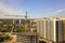 Apartment or office tall building under construction. Working builders and tower cranes on bright blue sky copy space background