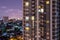 Apartment windows at night each with privacy in thier own home.