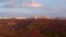 Apartments building at city skyline with autumn forest at sunset