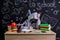 Apathetic and uninterested youngster sitting at the desk with a head leaned on the fists, surrounded with school