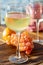 Aperitif cold white wine served in glasses with pink grapes on outdoor tessace witn sea view