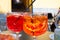 Aperol and Campari Spritz orange bitter long drink cocktails made with liqueur, prosecco sparkling wine, ice cubes and piece of