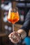 Aperol spritz drink. Bartender hand holding glass with Aperol S