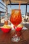 Aperol spritz served on a small wooden table on a hot tropical beach in summer in Italy