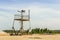 Apocalyptic landscape. Abandoned watch tower with rusted iron framework among on cracked and scorched land. Solidified white Earth