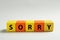 Apology. Word Sorry made of colorful cubes on light background. Space for text