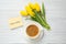 Apology. Yellow card with phrase I Am Sorry, cup of coffee and beautiful yellow tulips on white wooden table, flat lay